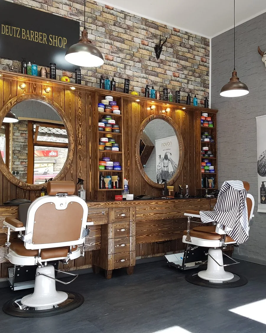 Barberstuhl vor den runden Holzspiegeln im Deutz Barber Shop